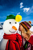 Girl kissing a snowman, Planai, Schladming, Styria, Austria