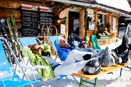 Drei Skifahrer sonnen sich vor einer Skihütte, Fageralm, Salzburg, Österreich