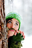 Young woman with a fake beard behind a tree