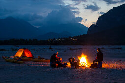 Lagerfeuer im Camp am Abend nach Kajaktour, Tagliamento, Tolmezzo, Italien