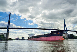 Container ship on the river Elbe beneath the Koehlbrandbruecke bridge, river Elbe, Hamburg, Germany