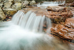 Stream cascading down over red rocks, Taugl, Salzkammergut, Salzburg, Austria