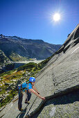 Frau klettert an Granitplatten, Azalee Beach, Grimselpass, Berner Oberland, Schweiz
