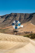 Mühle in den Dünen vor Gebirge Risco de Famara, Playa de Famara, Lanzarote, Kanarische Inseln, Spanien