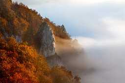 Rock needle with cross, mist in the valley of the Danube river, Upper Danube Nature Park, Baden- Wuerttemberg, Germany