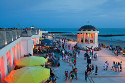 People sitting in a cafe on the beach promenade, Pavilion in the background, Borkum, Ostfriesland, Lower Saxony, Germany