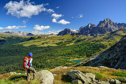 Frau schaut auf Lago Colbricon mit Pala im Hintergrund, Trans-Lagorai, Lagorai-Höhenweg, Lagorai, Dolomiten, UNESCO Welterbe Dolomiten, Trentino, Italien