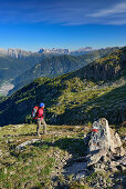 Woman hiking with view to Latemar range, Rosengarten, Langkofel and valley of Predazzo, Trans-Lagorai, Lagorai range, Dolomites, UNESCO World Heritage Site Dolomites, Trentino, Italy