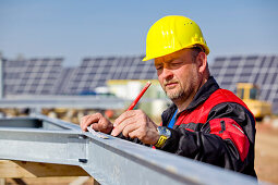 Bauarbeiten auf dem Solarpark am Peterswald, Bauarbeiter mit Helm bei der Arbeit, Neuental, Hessen, Deutschland, Europa