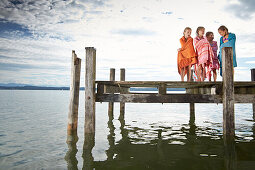 Girls wrapped in towels on a jetty at lake Starnberg, Upper Bavaria, Bavaria, Germany