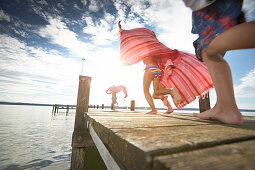 Children running along a jetty, lake Starnberg, Upper Bavaria, Bavaria, Germany