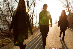 Gruppe junger Leute laufen eine Landstraße entlang, Großer Alpsee, Immenstadt im Allgäu, Bayern, Deutschland