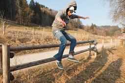 Junger Mann springt über einen Zaun, Großer Alpsee, Immenstadt im Allgäu, Bayern, Deutschland