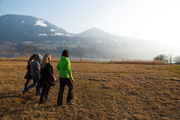 Young people crossing a meadow, Grosser Alpsee, Immenstadt, Bavaria, Germany