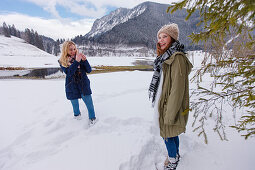 Junge Frau fotografiert Freundin im Schnee, Spitzingsee, Oberbayern, Bayern, Deutschland