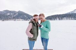 Two women with a smart phone, Spitzingsee, Upper Bavaria, Germany