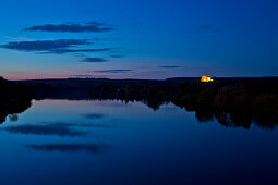 Illuminated Maria im Weingarten pilgrimage church and shoreline of Main river at dusk, Volkach, Franconia, Bavaria, Germany