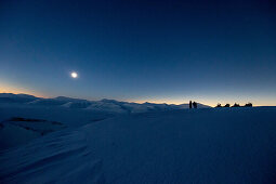 3 people with snowmobiles during the total solar eclipse, Spitzbergen, Svalbard, Norway