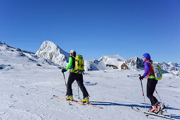 Man and woman back-country skiing ascending towards Schneespitze, Feuerstein in the background, Schneespitze, valley of Pflersch, Stubai Alps, South Tyrol, Italy
