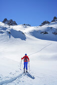 Frau auf Skitour steigt zum Col della Portiola auf, Valle di Stroppia, Valle Maira, Cottische Alpen, Piemont, Italien