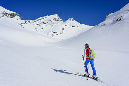 Woman back-country skiing ascending towards Monte Salza, Monte Salza, Valle Varaita, Cottian Alps, Piedmont, Italy