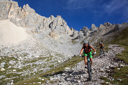 two mountain bikers on a single-trail at Latemar, Trentino Italy