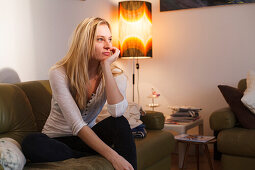 Young woman sitting on the sofa, Pensive