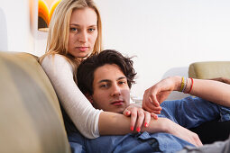 Junges Paar entspannt sich auf dem Sofa, Umarmung