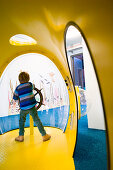 Young boy playing at submarine playground, Cuxhaven, North Sea, Lower Saxony, Germany