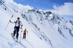 Two persons back-country skiing ascending towards Piz Sursass, Piz Nuna in the background, Piz Sursass, Sesvenna Alps, Engadin, Grisons, Switzerland