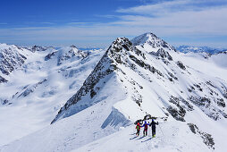 Several persons back-country skiing downhill from Pizzo Tresero, Punta San Matteo in background, Pizzo Tresero, Val dei Forni, Ortler range, Lombardy, Italy