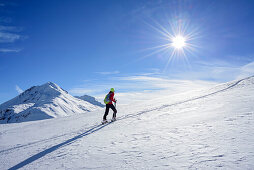 Woman back-country skiing ascending towards Munt Buffalora, Piz Daint in background, Munt Buffalora, Ofenpass, Sesvenna range, Engadin, Grisons, Switzerland