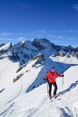Frau auf Skitour steigt zum Monte Soubeyran auf, im Hintergrund Monte Vallonasso und Monte Sautron, Monte Soubeyran, Valle Maira, Cottische Alpen, Piemont, Italien