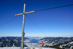 Frau auf Skitour am Gipfel des Setzberg, Tegernsee im Hintergrund, Setzberg, Bayerische Alpen, Oberbayern, Bayern, Deutschland