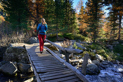 Frau wandert auf Brücke über Bach am Ufer des Saoseosees (2028 m), Valposchiavo, Graubünden, Schweiz