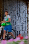 Frau schiebt ihr Fahrrad, Burghausen, Chiemgau, Bayern, Deutschland