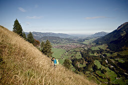 Young man hiking up a mountain on a sunny day, Oberstdorf, Bavaria, Germany