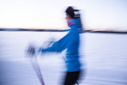 Young woman cross-country skiing at sunset, Allgaeu, Bavaria, Germany