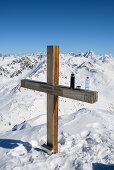 Summit cross of the Schwarzhorn (3147 m), in the background on the right-hand side Piz Linard (3410 m), Grisons, Switzerland, Europe
