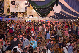 People celebrate in giant beer tent at Bayreuther Volksfest beerfest and amusement park, Bayreuth, Franconia, Bavaria, Germany