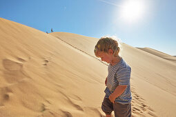 Boy in a sand dune, Dune 7, Walvis Bay, Erongo, Namibia