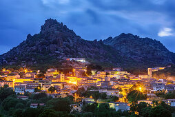 Illuminated village of Aggius with mountains, Aggius, Sardinia, Italy