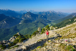 Frau beim Wandern steigt zum Hochstaufen auf, Berchtesgadener Alpen, Loferer Steinberge und Chiemgauer Alpen im Hintergrund, Hochstaufen, Chiemgauer Alpen, Oberbayern, Bayern, Deutschland