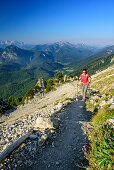 Frau beim Wandern steigt zum Hochstaufen auf, Loferer Steinberge und Chiemgauer Alpen im Hintergrund, Hochstaufen, Chiemgauer Alpen, Oberbayern, Bayern, Deutschland