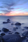 Strand mit Steinen im Meer nach Sonnenuntergang, Binz, Insel Rügen, Ostsee, Mecklenburg Vorpommern, Deutschland