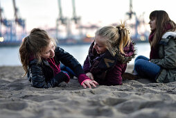 3 girls viewing the port at the Elbe River beach, Oevelgoenne, Hamburg, Germany, Europe