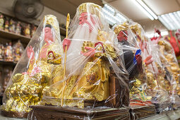 temple shop, figures, gods,  Buddhas wrapped in clear plastic, religion, superstion, decorations, Singapore