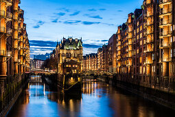 Blick in der Abenddaemmerung auf das Wasserschloss in der alten Speicherstadt, Hafencity Hamburg, Norddeutschland, Deutschland