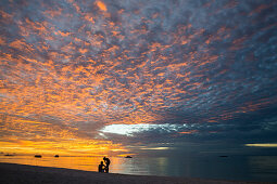 Sonnuntergang mit zwei Personen, Meeru Island Resort, Meerufenfushi, Nord-Male-Atoll, Malediven