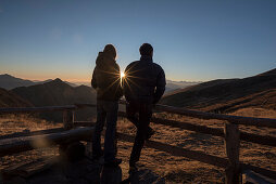 A couple in front of the Borgna Hut at sunset, Val Verzasca, Lepontine Alps, canton of Ticino, Switzerland